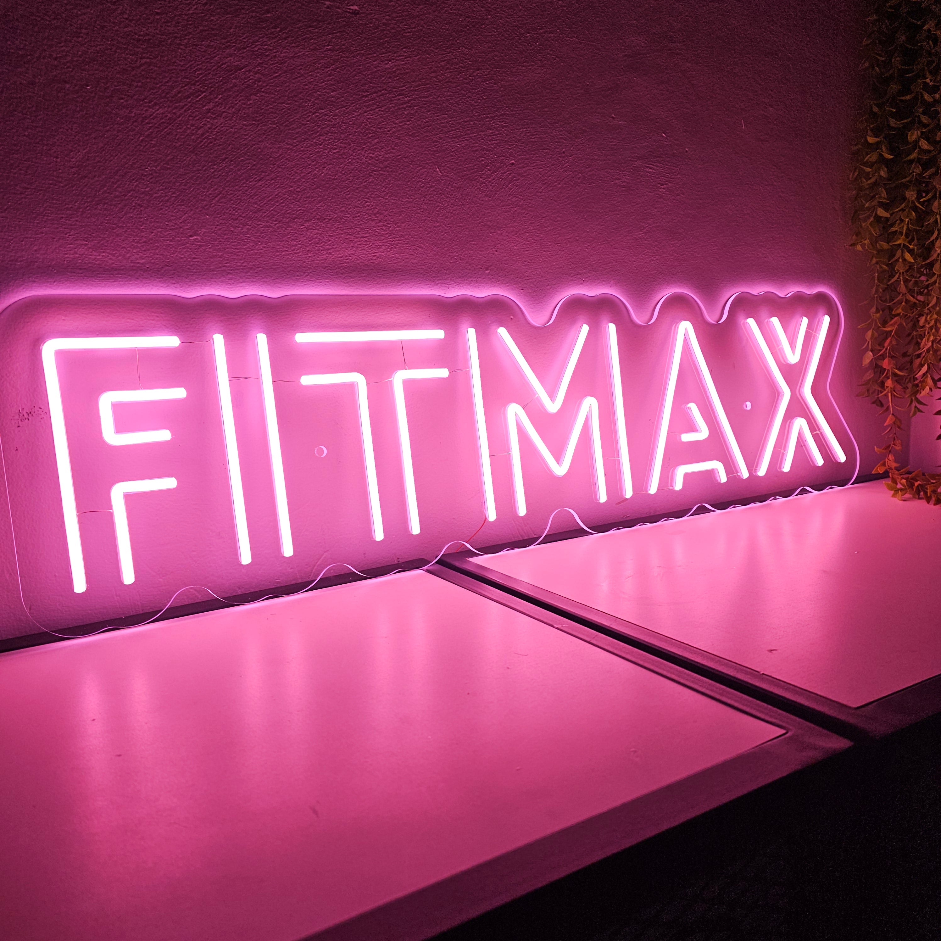 Neon sign with 'FITTMAX' on a pink background